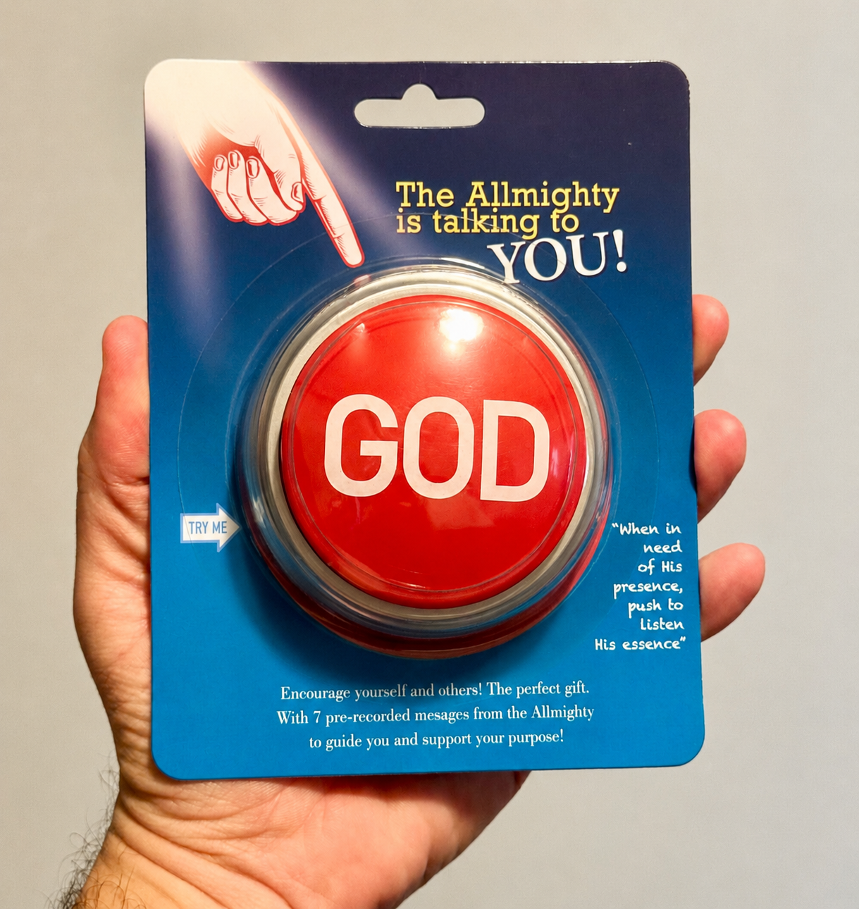 Hand holding the GOD Talking Button™ blister pack